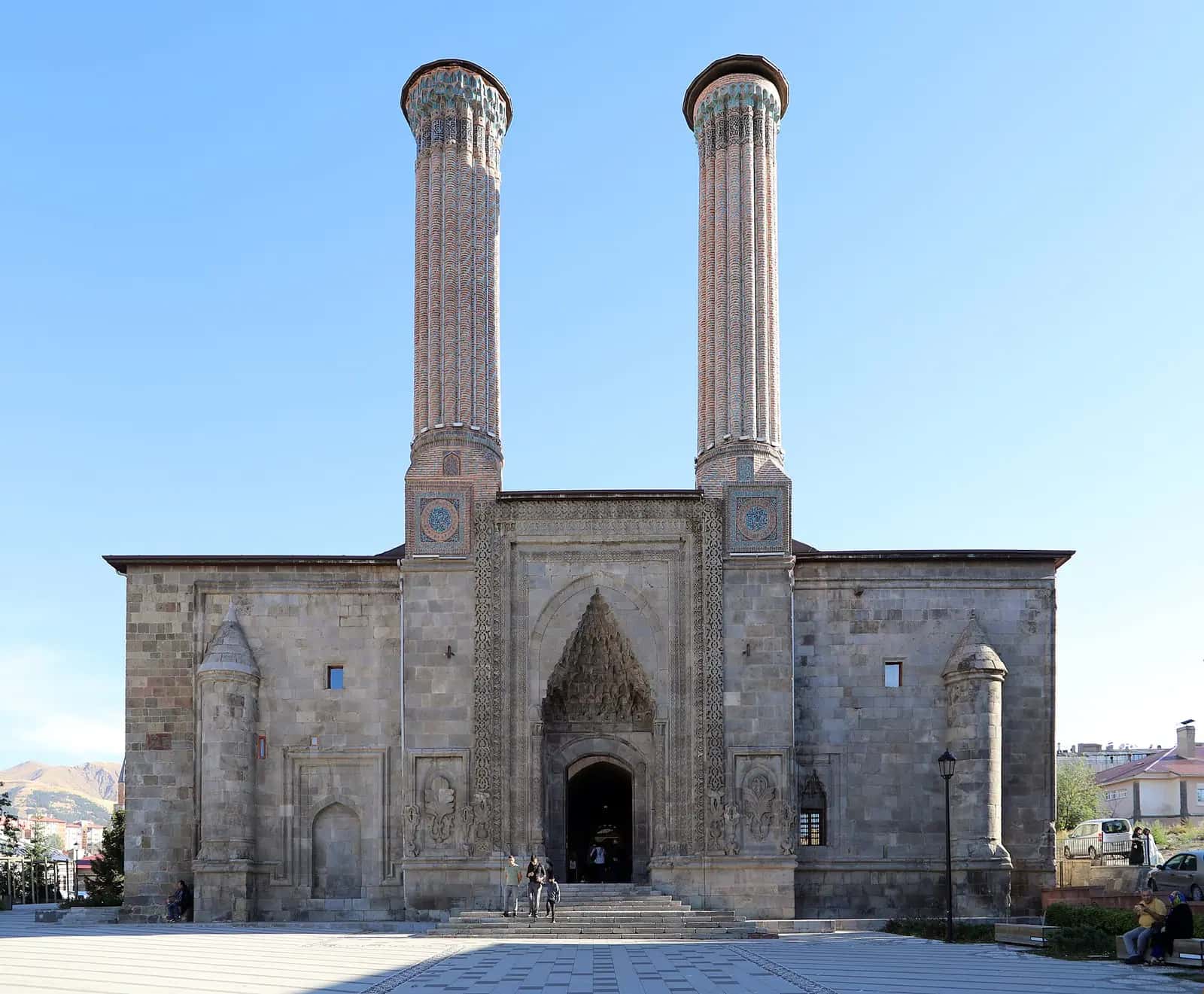 Erzurum'da Çifte Minareli Medrese'nin iki tuğla minaresi ve taç kapılı cephesi