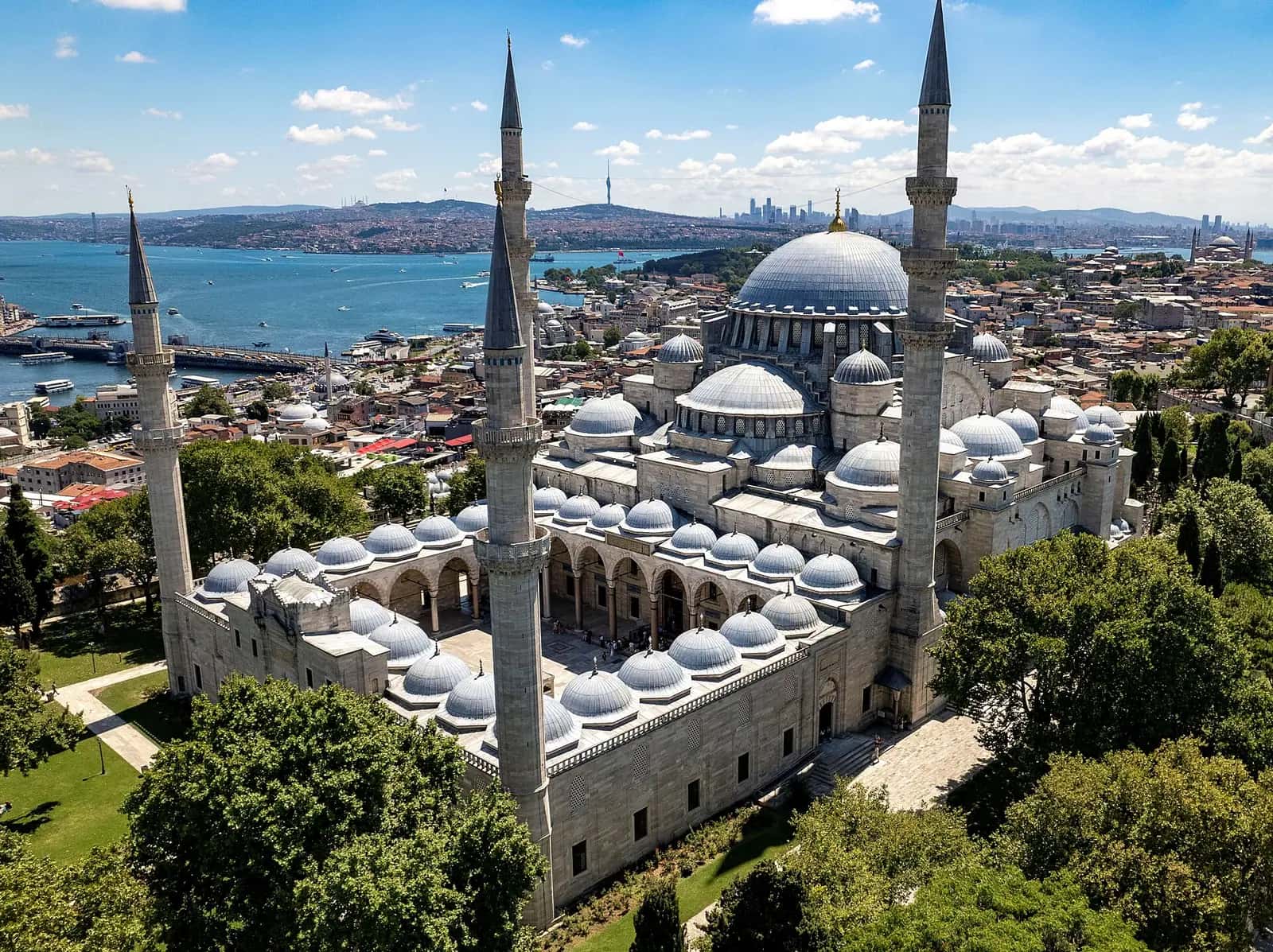 Süleymaniye Camii'nin merkezî kubbesi, yarım kubbeleri ve dört minaresinin dışarıdan görünümü.
