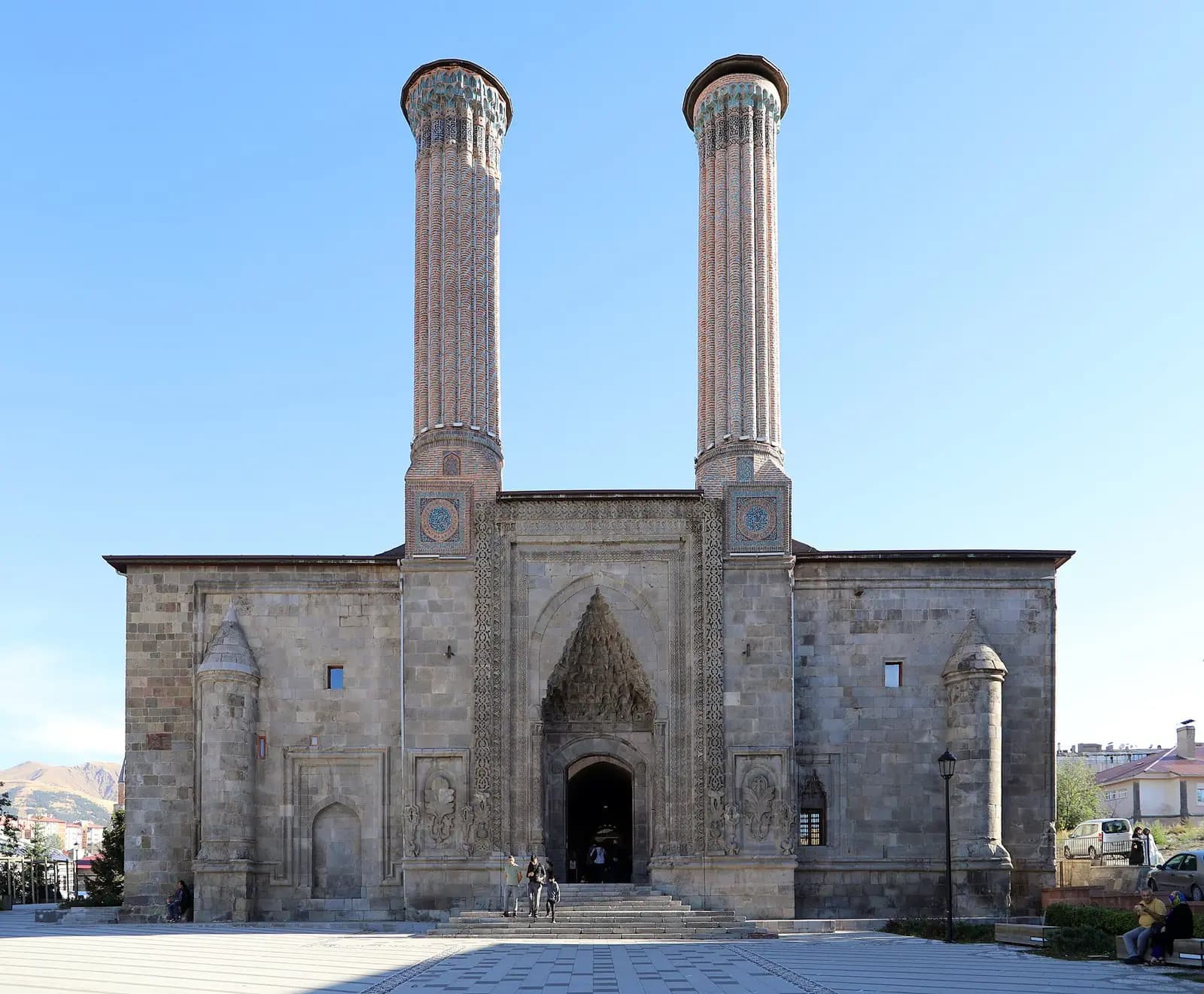 Erzurum'da Çifte Minareli Medrese'nin iki tuğla minaresi ve taç kapılı cephesi