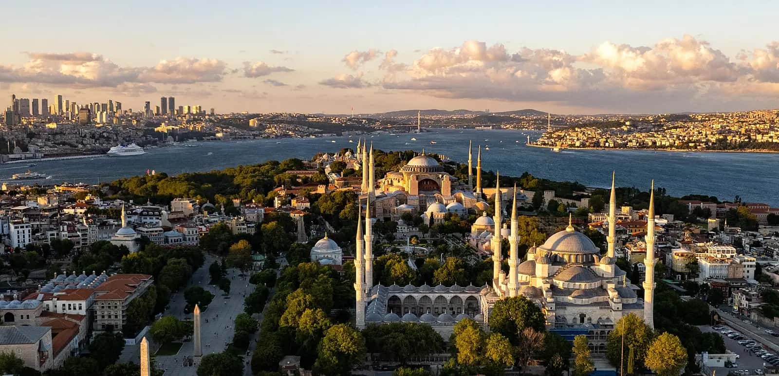 İstanbul'un tarihî yarımadası; tepelerde camilerin kubbe ve minareleri, arka planda modern binalar.
