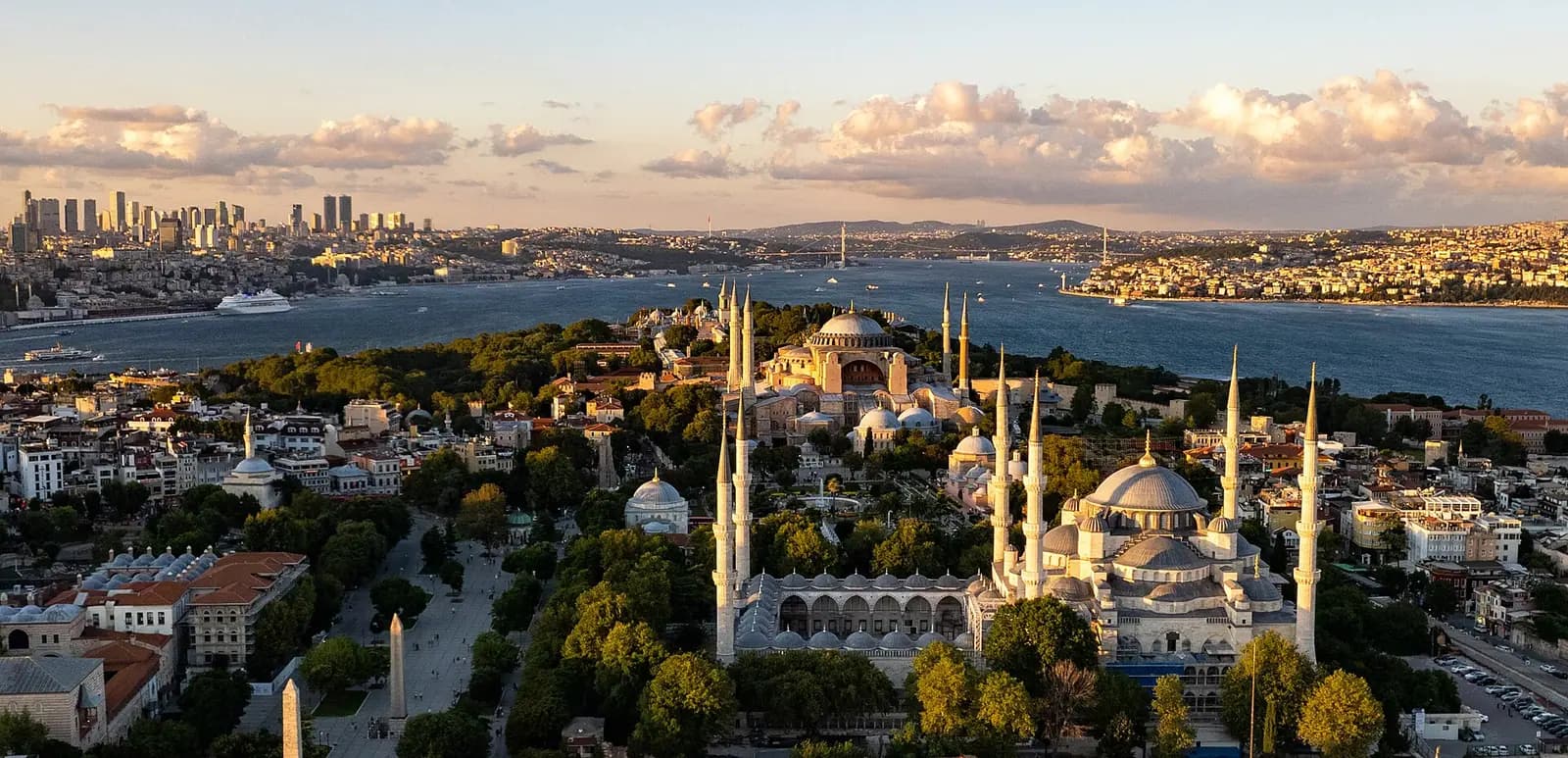 İstanbul'un tarihî yarımadası; tepelerde camilerin kubbe ve minareleri, arka planda modern binalar.