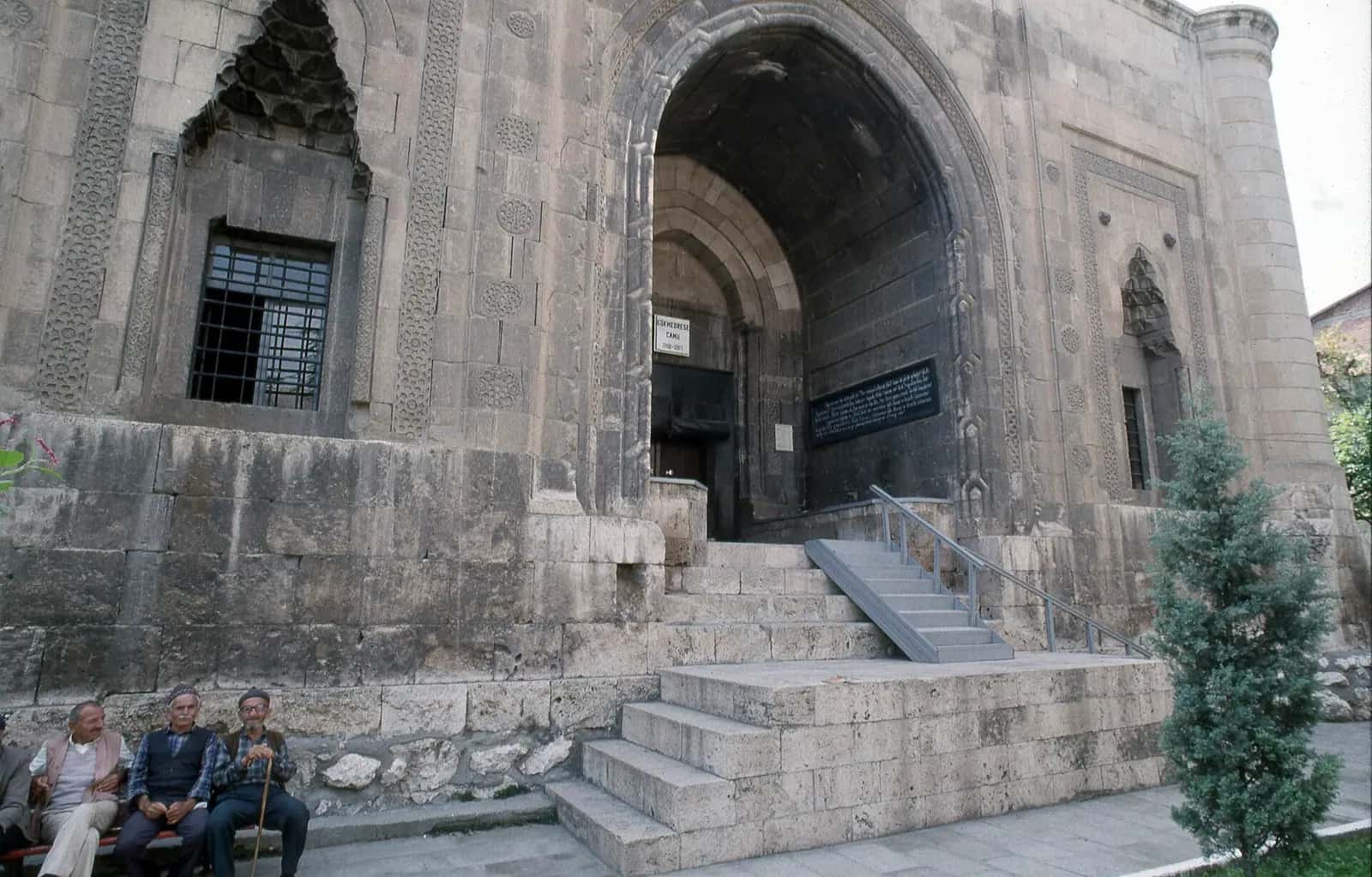 Gökmedrese Camii'nin sivri kemerli taç kapısı ve masif kesme taş cephesi
