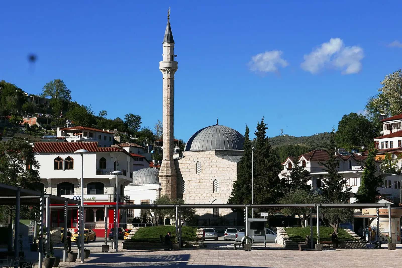 Berat'taki Kurşunlu Camii'nin kubbesi ve ince taş minaresi, arkada yeşil tepeler