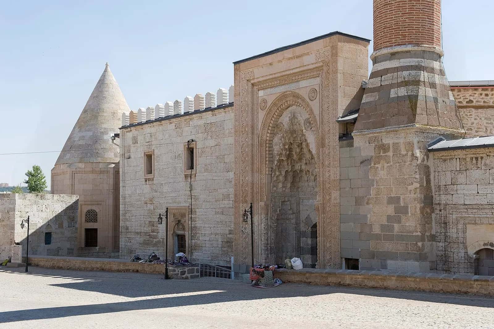 Eşrefoğlu Camii'nin kesme taş taç kapısı, mazgallı ön cephesi ve minaresi