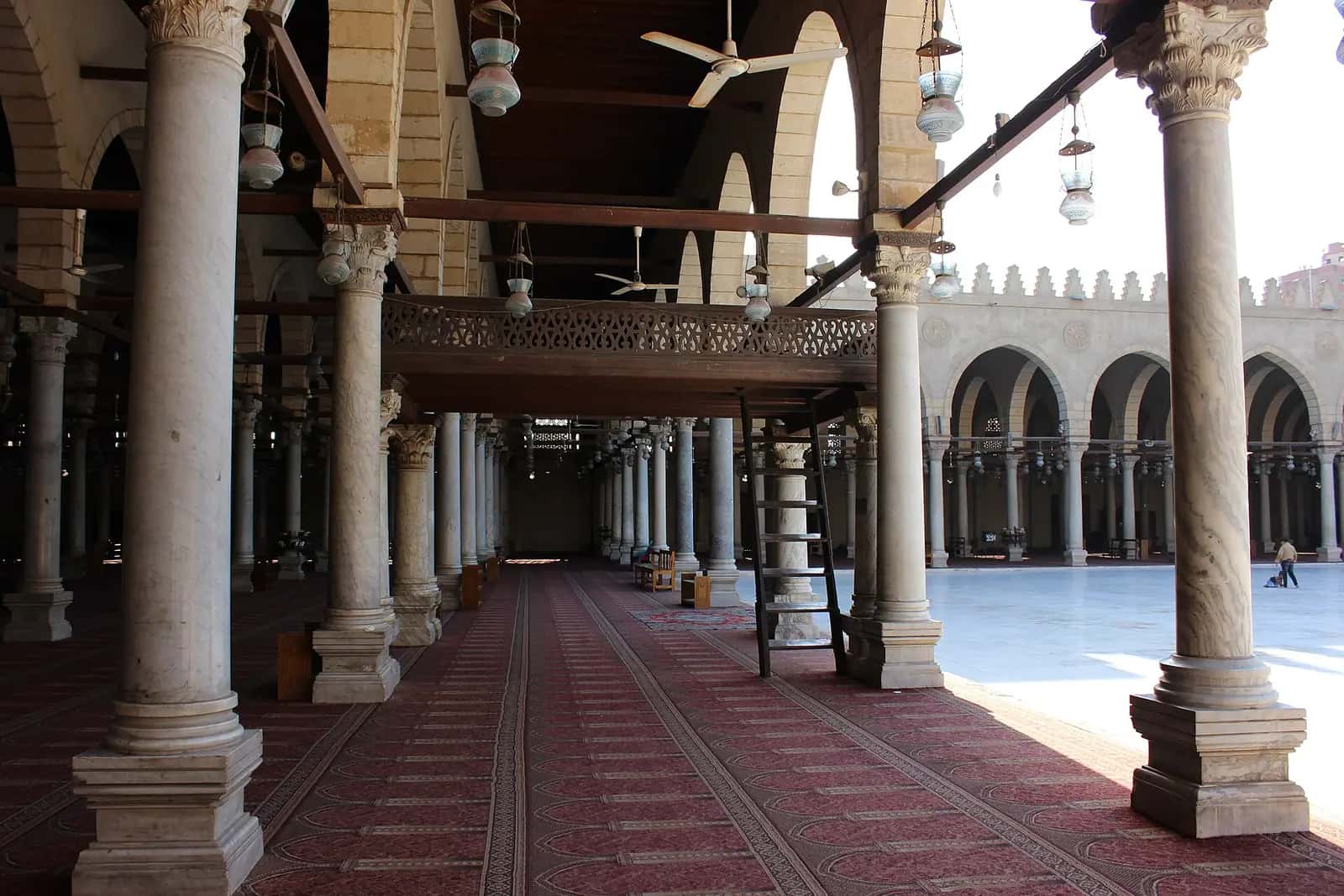 Amr b. Âs Camii'nin sütunlu harimi, halı döşeli zemini ve arkadaki kemerli avlu revakları