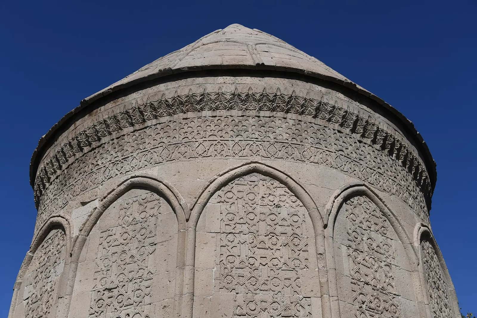 Döner Kümbet'in kabartmalı panolarla süslü on iki cepheli taş gövdesi