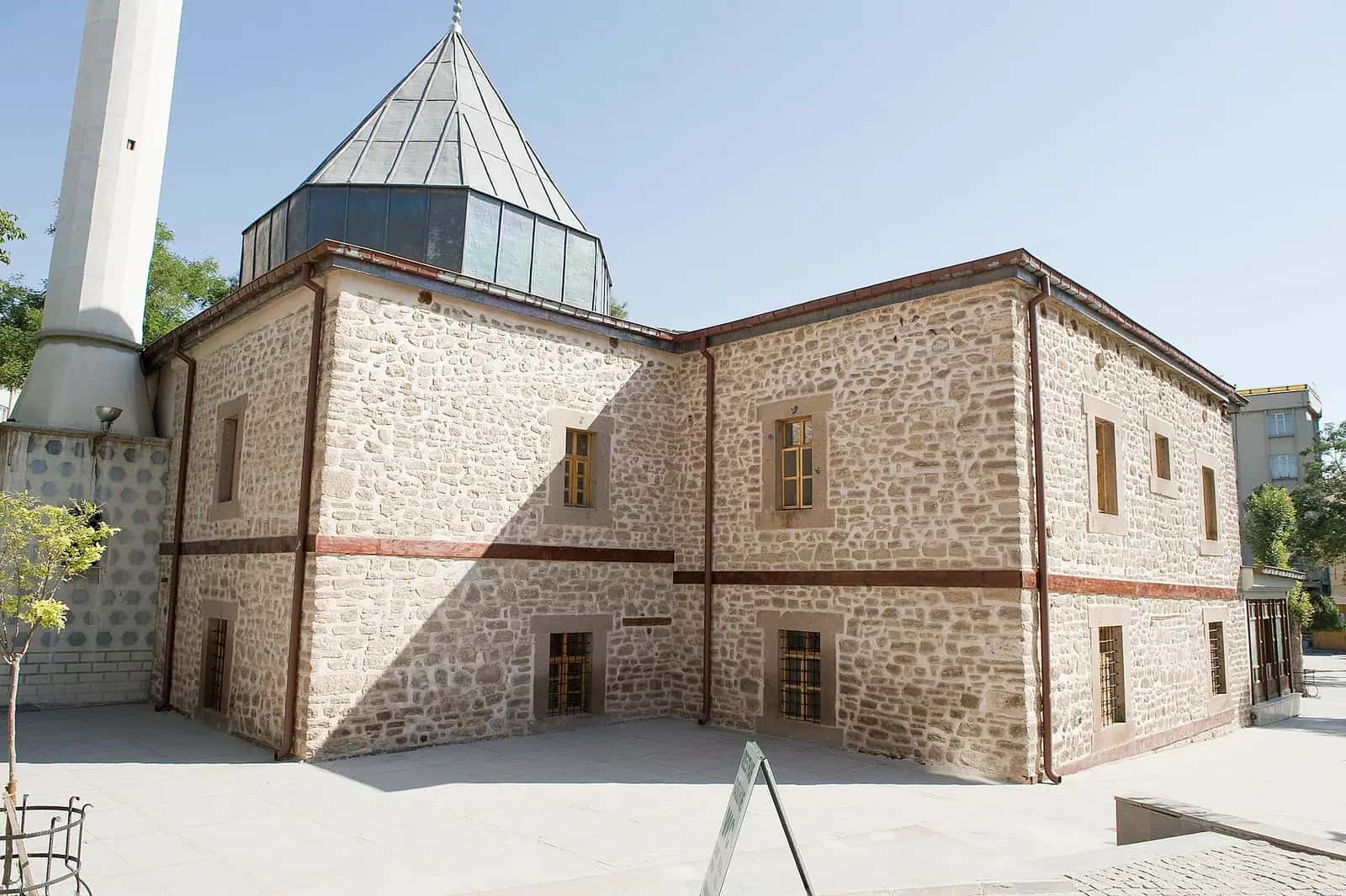 Şems-i Tebrîzî Camii'nin taş duvarları ve piramidal külahlı türbe bölümü