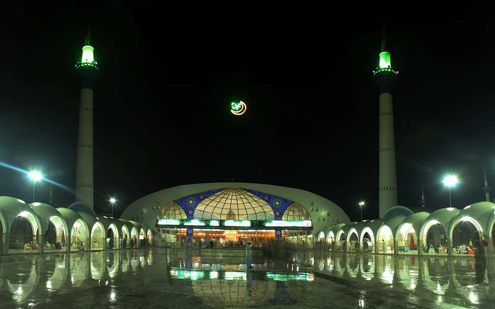 Gece aydınlatılmış Dâtâ Dârbâr külliyesinin avlusu, iki minaresi ve kubbesi