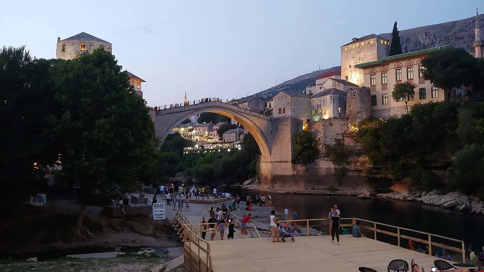 Gün batımında Neretva üzerindeki tek kemerli Mostar Köprüsü ve iki yanındaki taş yapılar