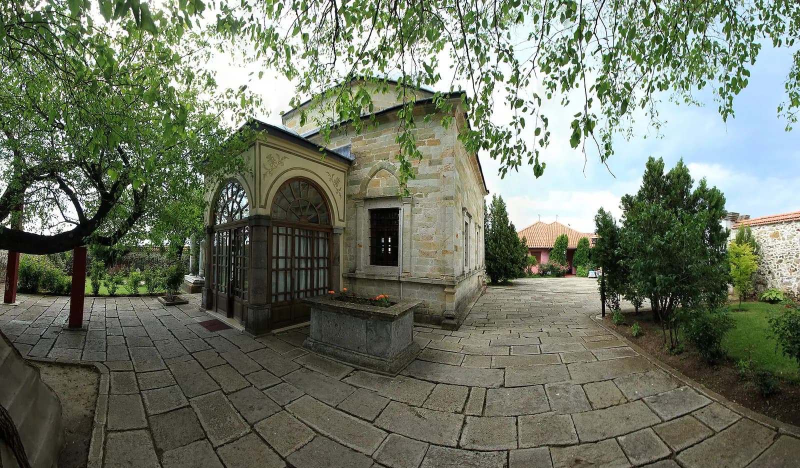 Sultan Murad Türbesi'nin kesme taş gövdesi, revaklı girişi ve taş döşeli avlusu