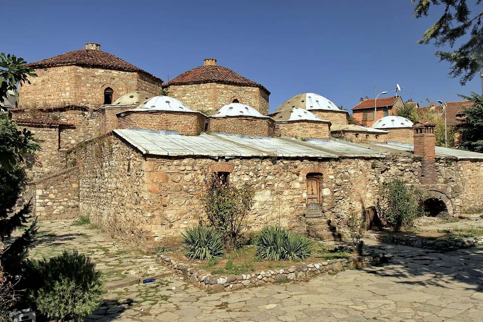 Gazi Mehmed Paşa Hamamı'nın taş duvarları ve çok sayıda küçük kubbesi