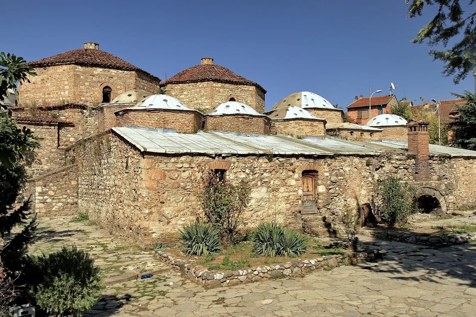 Gazi Mehmed Paşa Hamamı'nın taş duvarları ve çok sayıda küçük kubbesi