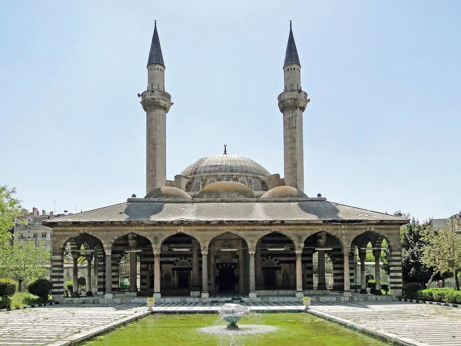 Süleymaniye Tekkiyesi camisinin kubbesi, iki ince minaresi ve önündeki havuz
