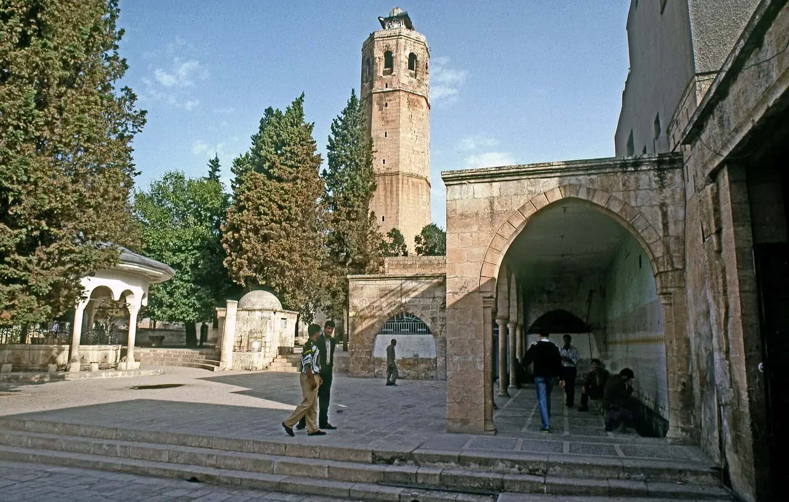Şanlıurfa Ulu Camii'nin avlusu, kemerli girişi ve saat eklenmiş eski çan kulesi