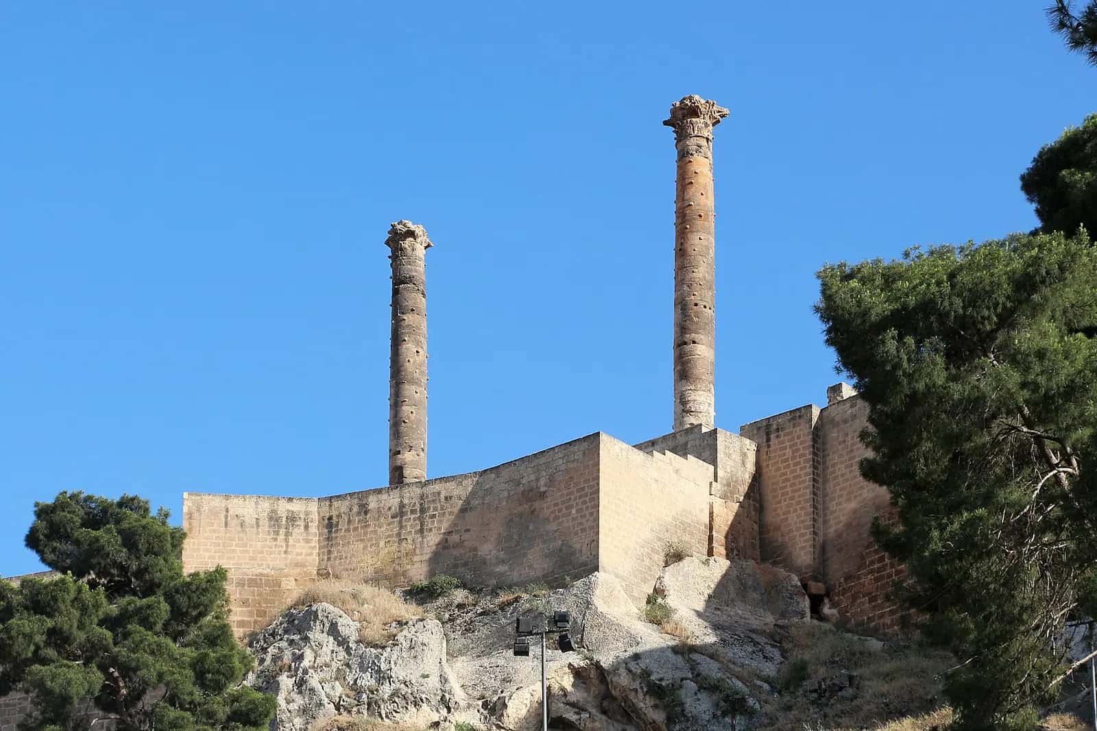 Urfa Kalesi'nin taş surları ve üzerinde yükselen Korint başlıklı iki antik sütun