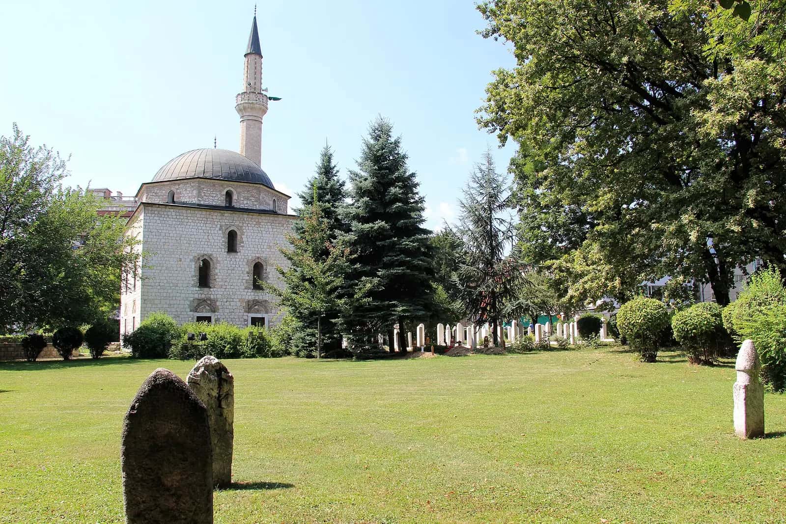 Ali Paşa Camii'nin kubbesi, minaresi ve önündeki mezar taşlarıyla bahçesi