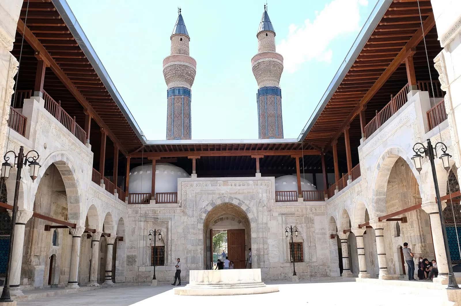 Gök Medrese'nin iki katlı revaklı avlusu ve arkada çini süslemeli çifte minaresi