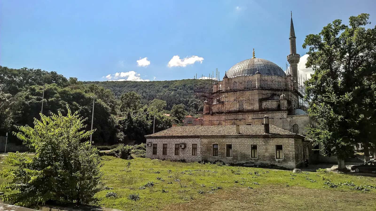 Şumnu'daki Tombul Camii'nin payanda kuleli kubbesi, minaresi ve önündeki medrese binası
