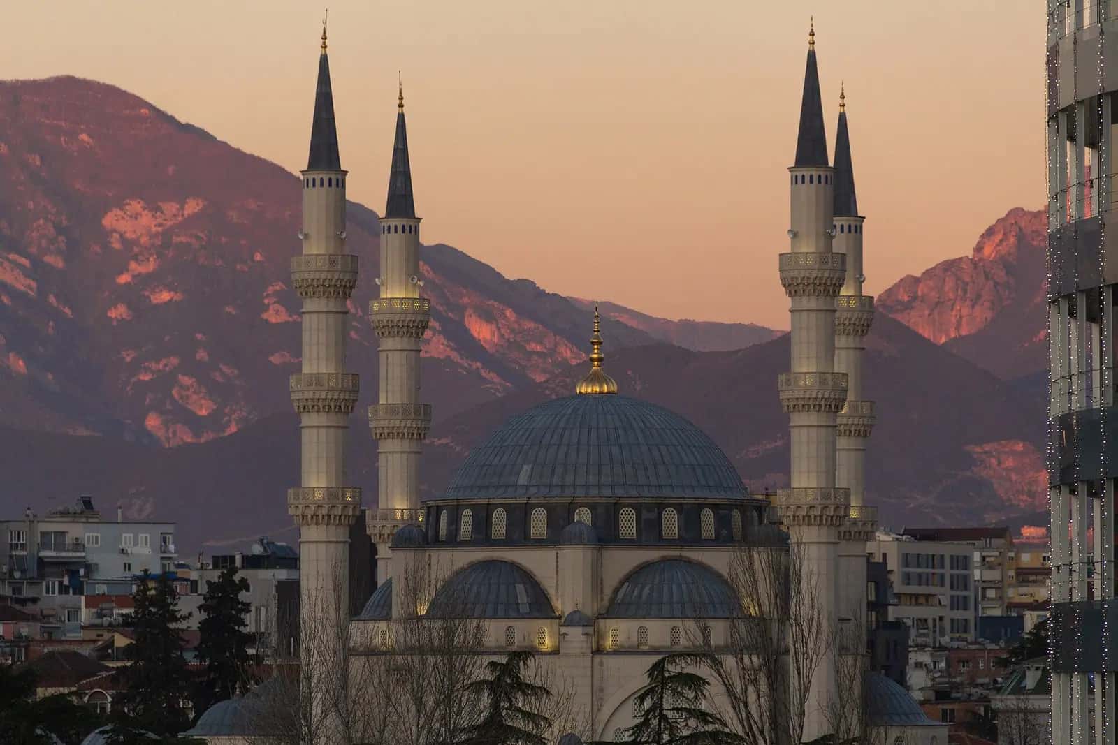 Gün batımında Namazgâh Camii'nin büyük kubbesi ve minareleri, arkada dağlar