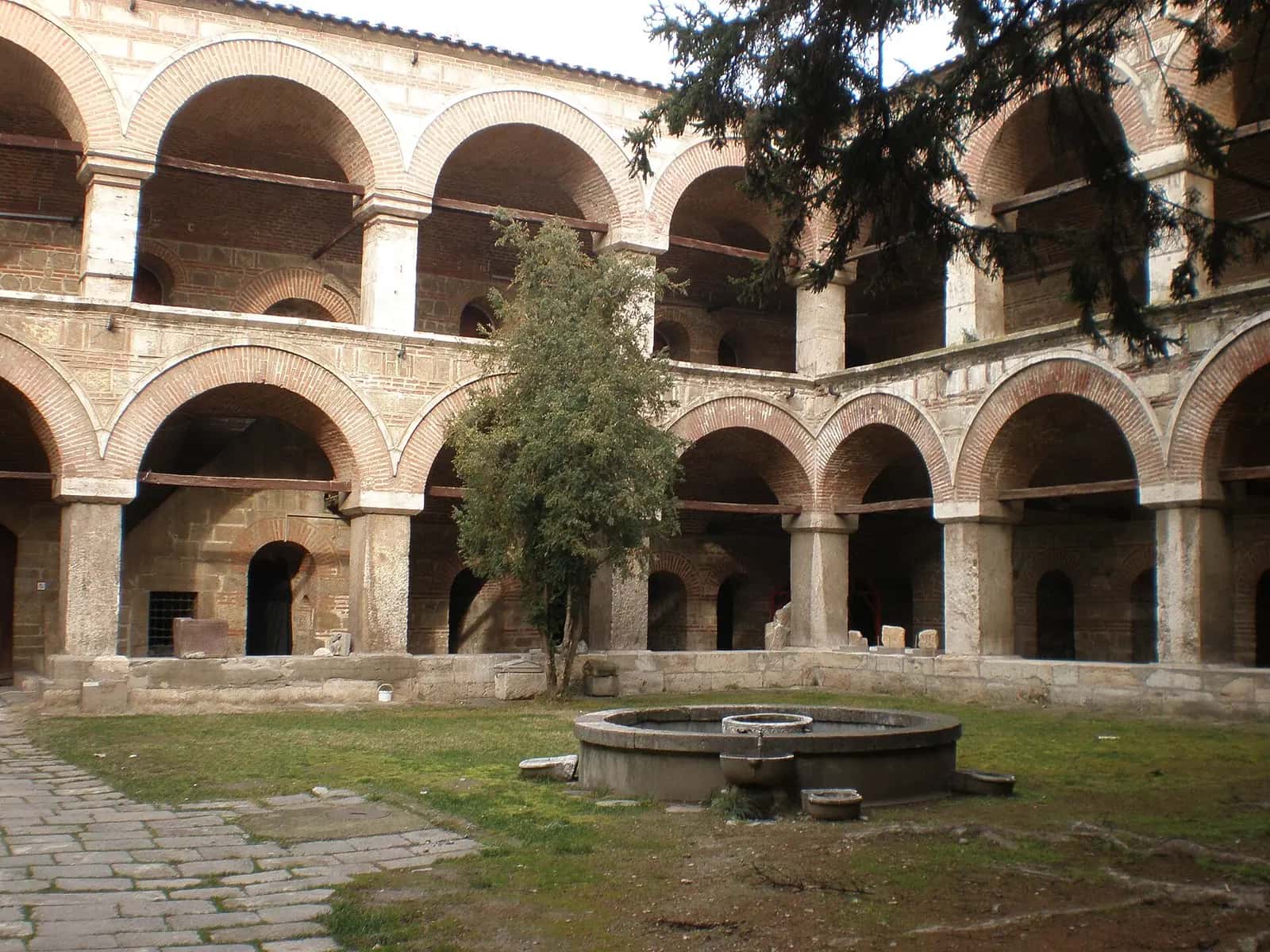 Kurşunlu Han'ın iki katlı kemerli revakları ve avlusundaki çeşme